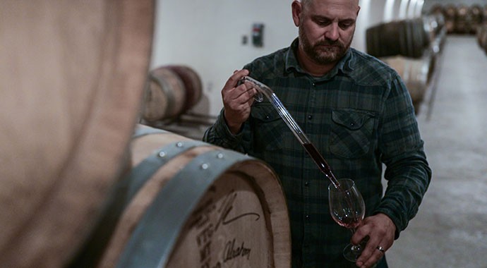 Winemaker Mike Waller in the cave tasting from barrels