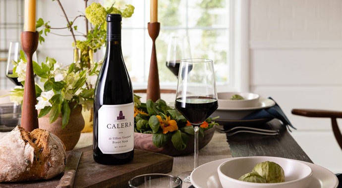 Calera Mt. Harlan Pinot Noir on table with a glass on wine and bread